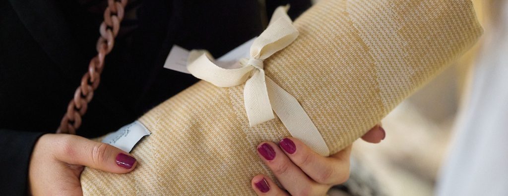 Manta natural doblada con lazo, símbolo de comodidad y tejidos naturales para dormir mejor.